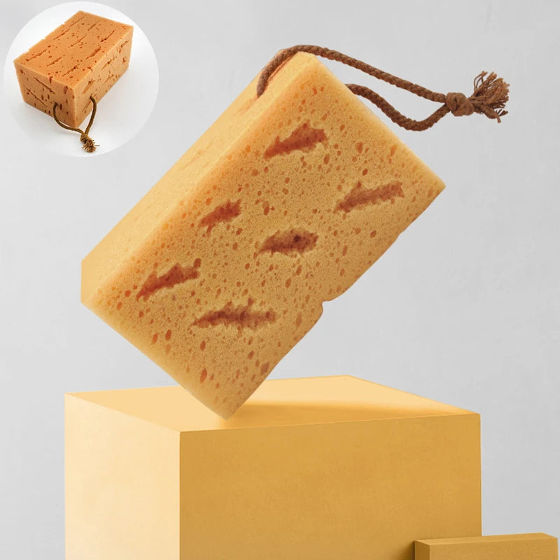 Large orange sea sponge with brown hanging loop for bath and shower.