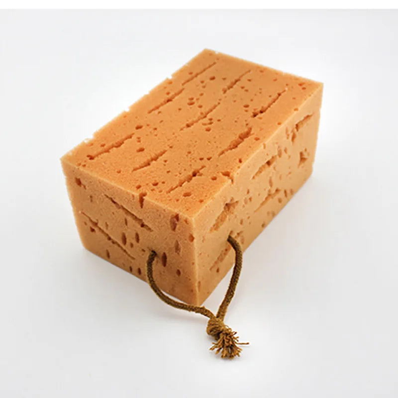 Orange bath sponge with rope detail for easy hanging and storage.