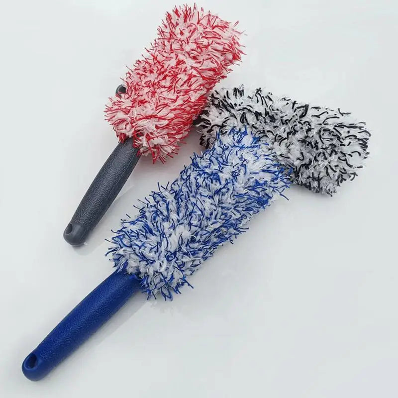 Three microfiber car wheel cleaning brushes with red, black, and blue handles.