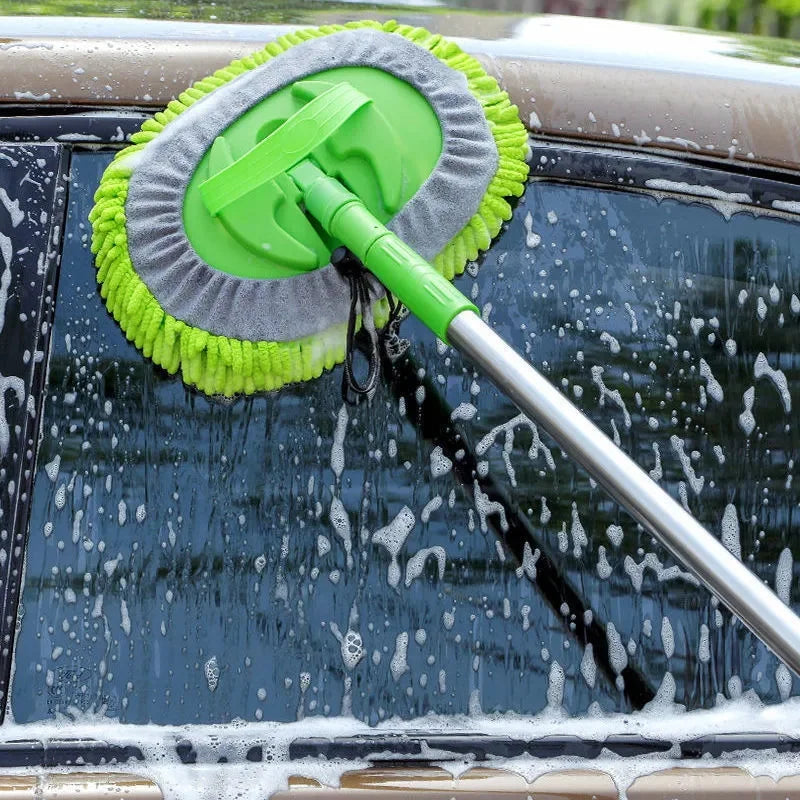Car wash mop with extending handle cleaning a car window.