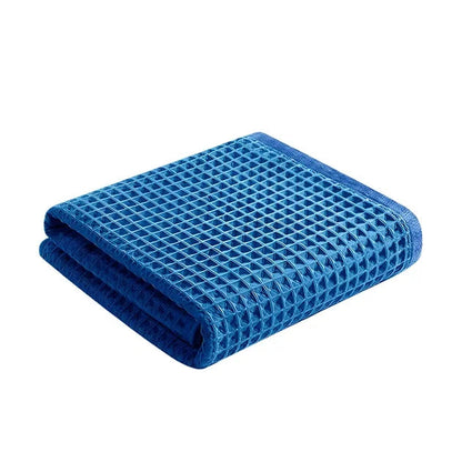 Folded blue waffle weave towel. Highly absorbent bath or kitchen towel.