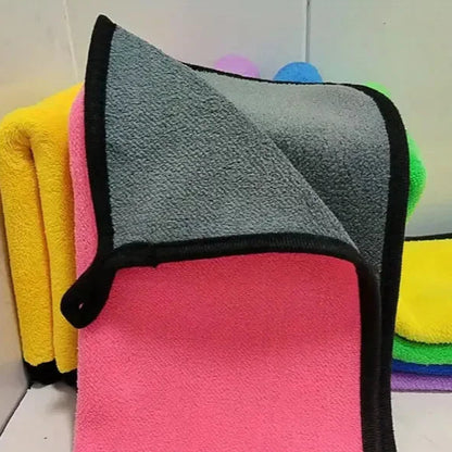 Close-up of colorful microfiber cleaning cloths with black trim, showing the towel's texture and dual-sided design.