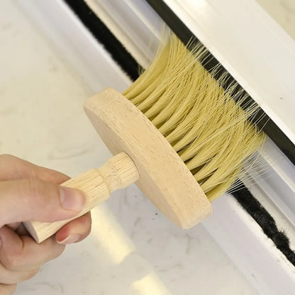 Window track cleaning brush with wooden handle removing debris.
